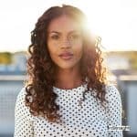 woman drying her hair outside and showing how to air dry curly hair fast